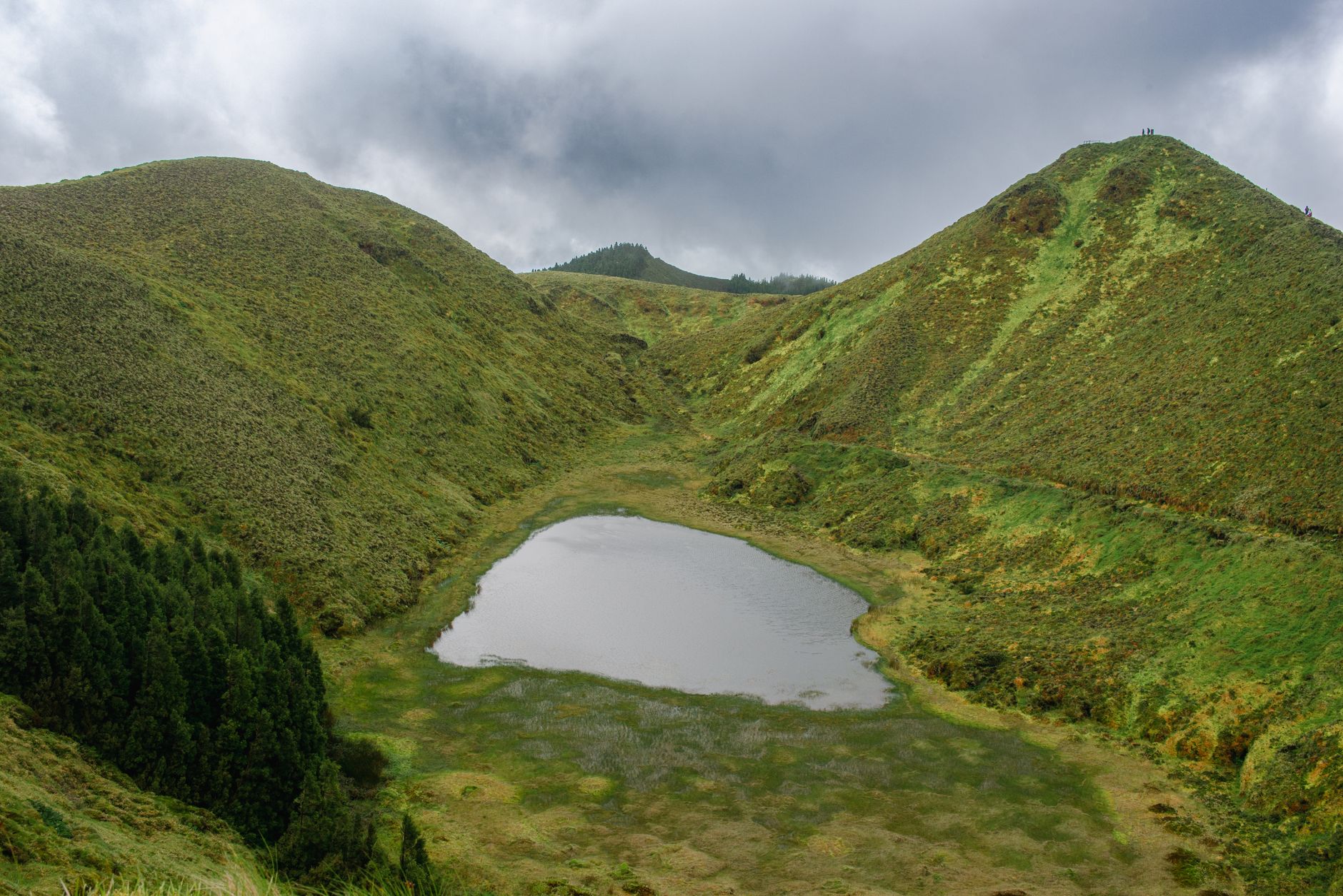 Danau kawah berwarna hijau di tengah pegunungan