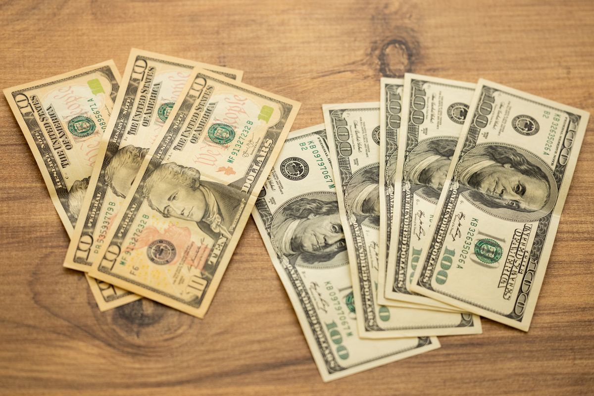 Uang kertas dolar AS berjejer di atas meja kayu